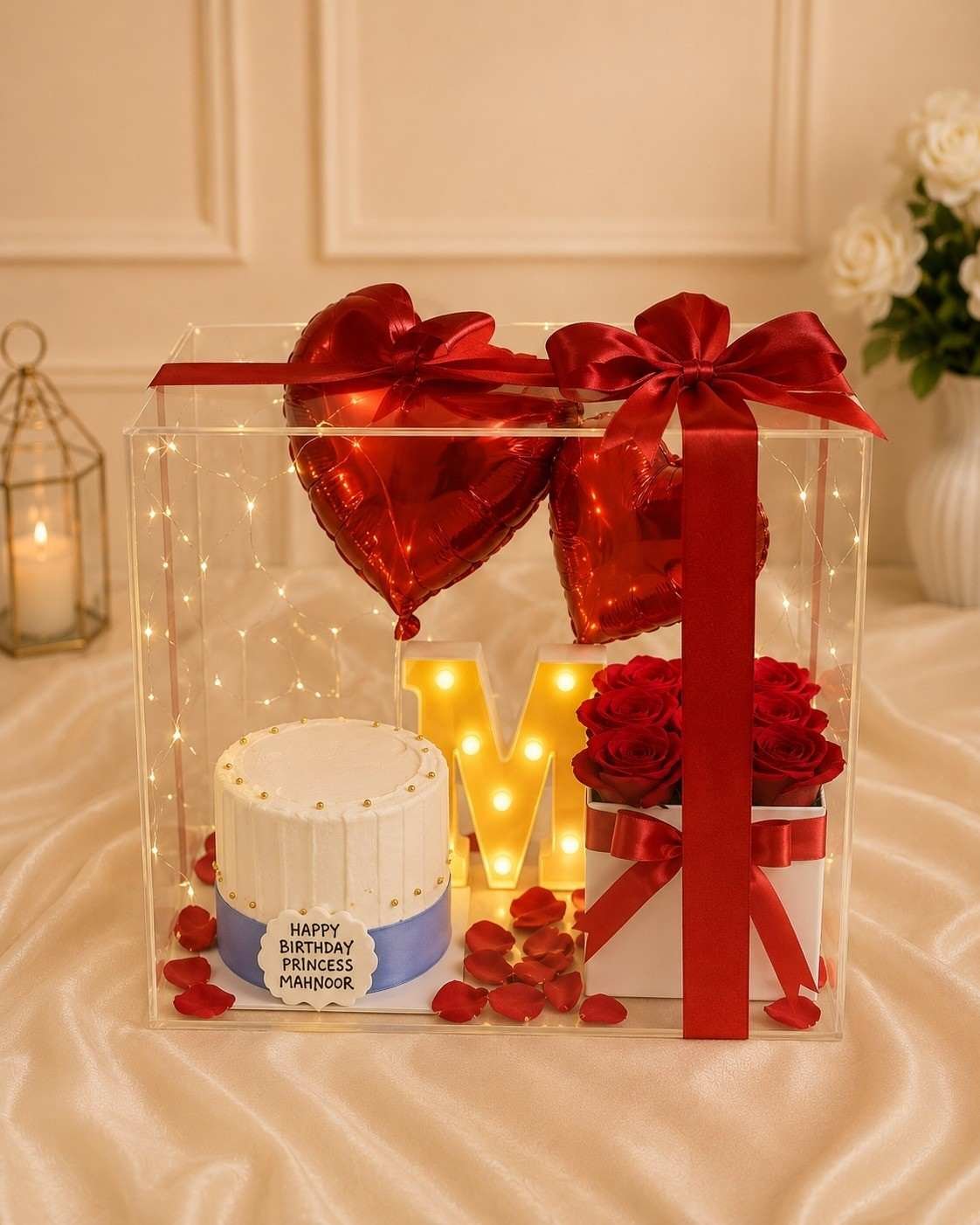 Clear acrylic box with a custom cake and balloons for flower delivery in Lahore