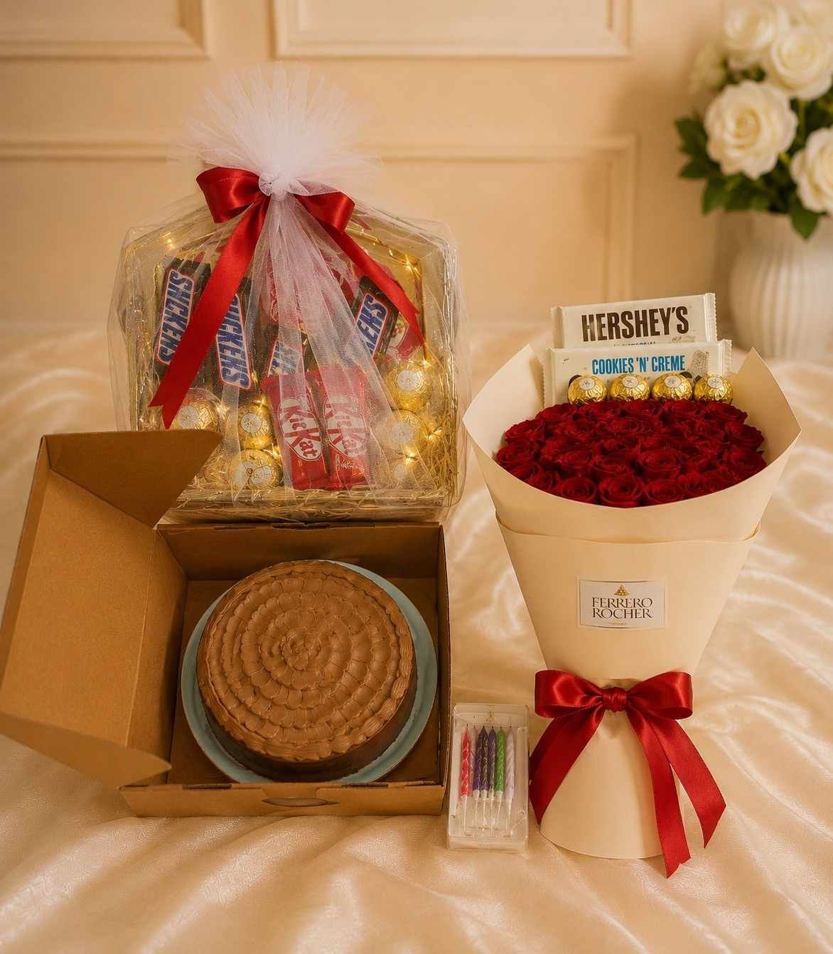 Fresh red rose bouquet next to a chocolate cake and gift box for people who send flowers and cakes