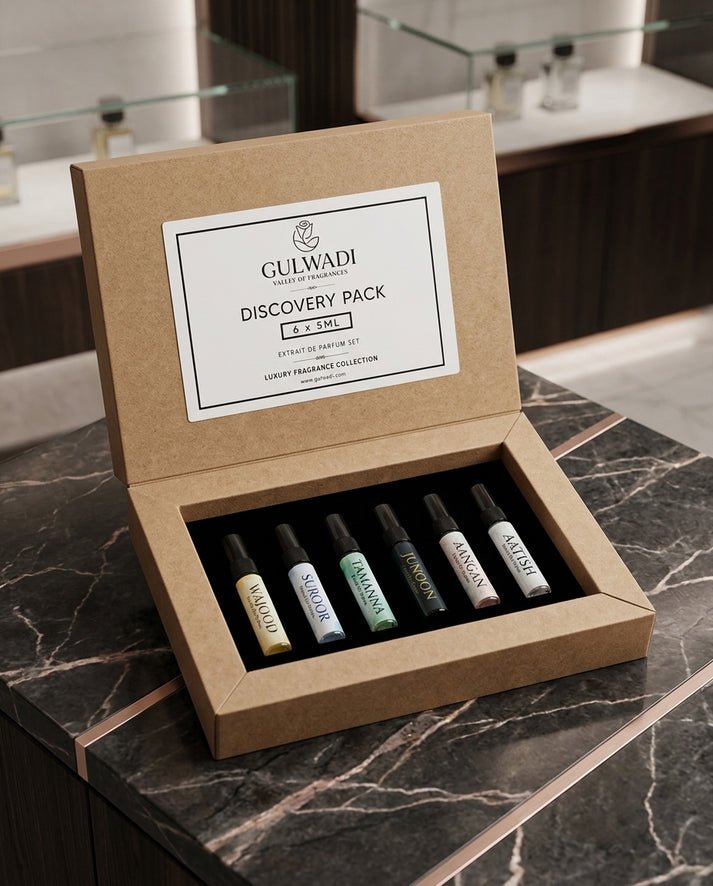 An open kraft gift box containing a Gulwadi Discovery Pack with six 5ML extrait de parfum tester vials on a marble surface