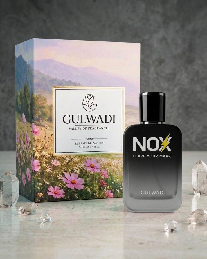 A man in a sharp grey suit holding a bottle of NOX Perfume by Gulwadi featuring white pepper, bergamot, and tonka bean
