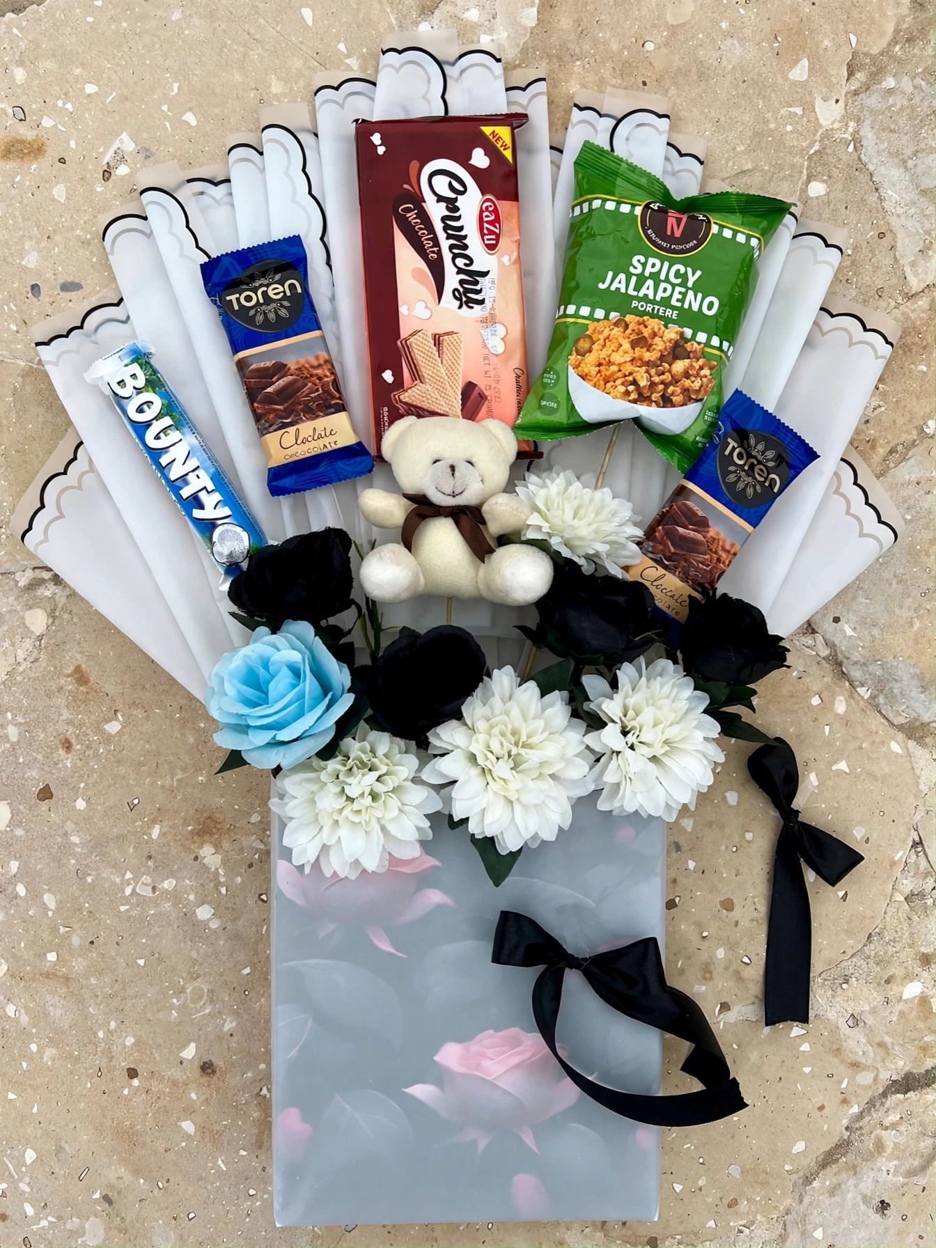Chocolate snack gift bag flat lay on a stone surface