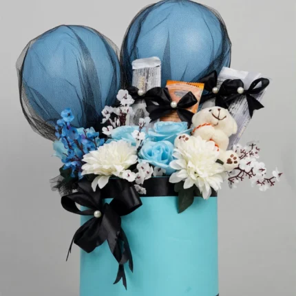 Teal gift box with blue balloons and blue and white flowers