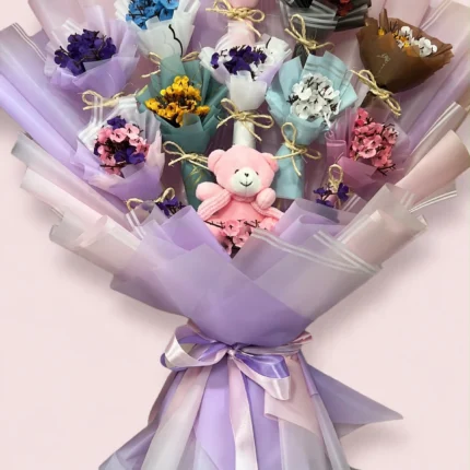 Bunch of mini handmade bouquets with pink teddy in lavender wrapping