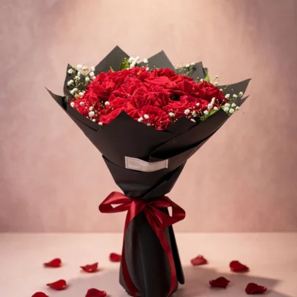 Grand bouquet of fresh red roses with baby's breath in black wrapping with red ribbon