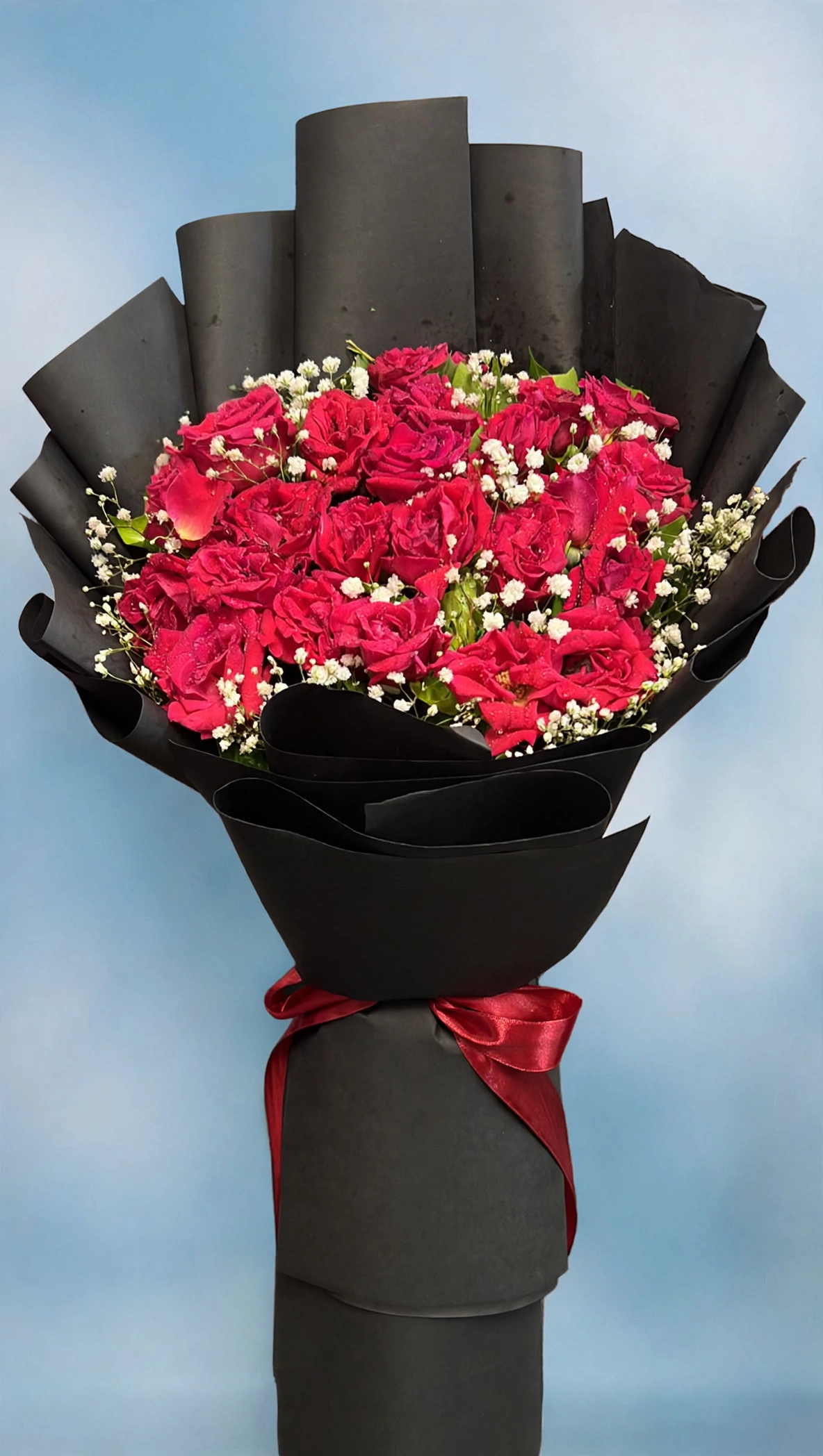 Close-up of fresh deep red roses and baby's breath in the premium bouquet